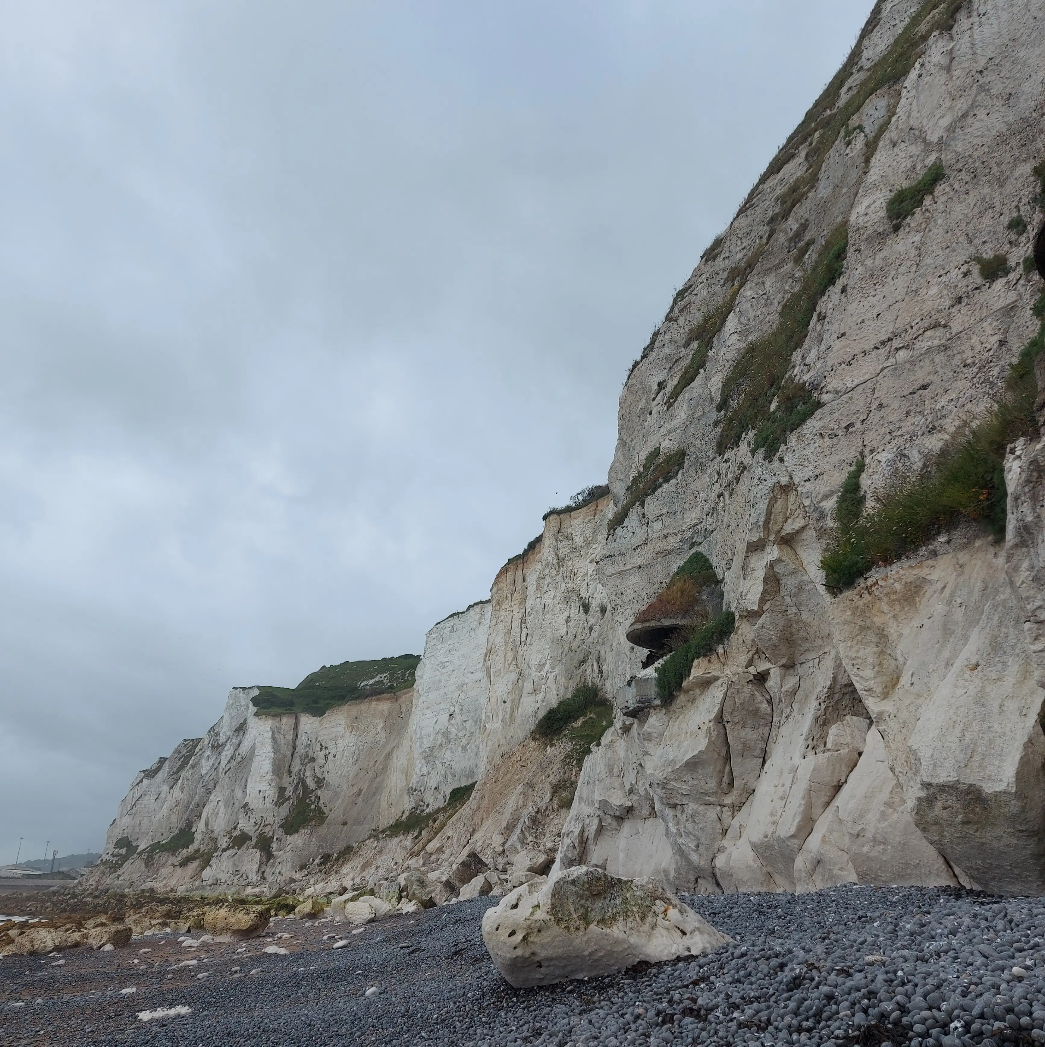 2 picture collage: White cliffs of Dover with grey sky, Canterbury canal with old buildings on the side